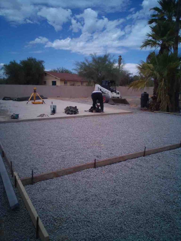 Crew preparing a backyard slab with laser leveling